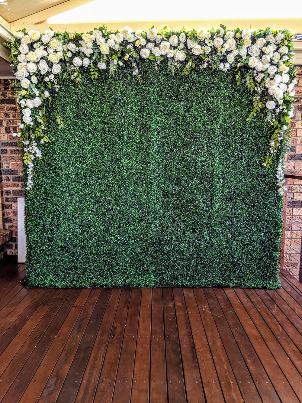 green hedge with top floral white arch
